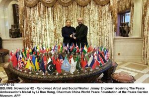 APP57-02 BEIJING: November 02 - Renowned Artist and Social Worker Jimmy Engineer receiving The Peace Ambassador's Medal by Li Ruo Hong, Chairman China World Peace Foundation at the Peace Garden Museum. APP